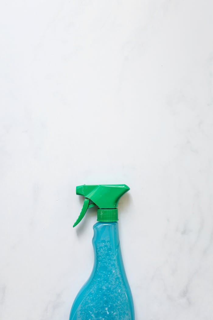 Close-up of a blue spray bottle with copy space on a white background.